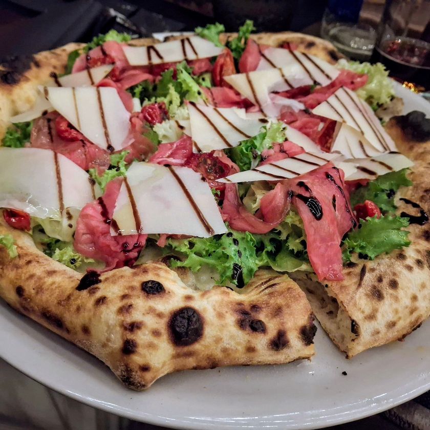 Pizza con carpaccio, scaglie di grana, rucola e riduzione di balsamico